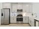 Sleek kitchen features stainless steel appliances, modern white cabinets, and a tiled backsplash at 17885 Cherished Loop, Bradenton, FL 34211