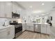 Open kitchen boasts stainless steel appliances, a farmhouse sink, and a view into the living space at 17885 Cherished Loop, Bradenton, FL 34211