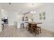 Bright dining area and kitchen with white cabinets and wood floors, perfect for entertaining guests at 17885 Cherished Loop, Bradenton, FL 34211