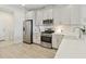 Modern kitchen features stainless steel appliances, white cabinets, and quartz countertops for a clean, stylish look at 17885 Cherished Loop, Bradenton, FL 34211
