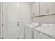 Efficient laundry room with washer, dryer, and overhead storage cabinets for a tidy space at 17885 Cherished Loop, Bradenton, FL 34211