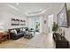 Bright living room with a black leather sectional and sliding glass doors to the lanai at 17885 Cherished Loop, Bradenton, FL 34211