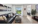 Comfortable living room featuring a leather sofa, large ottoman, and slider to the patio at 17885 Cherished Loop, Bradenton, FL 34211