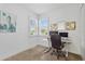 The home office has a flat screen computer monitor, artwork, a modern desk, and a window at 17885 Cherished Loop, Bradenton, FL 34211