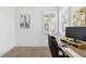 A home office is decorated with a flat screen computer monitor, artwork, and a modern desk at 17885 Cherished Loop, Bradenton, FL 34211