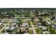 Aerial view of a residential neighborhood featuring single-story homes and lush trees near a community lake at 1789 Elm Dr, Venice, FL 34293
