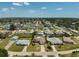 Neighborhood aerial view featuring single-story homes, mature trees, and a tranquil community lake at 1789 Elm Dr, Venice, FL 34293