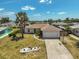 An aerial view shows a well-kept property with landscaping and an extended driveway, surrounded by a residential neighborhood at 1789 Elm Dr, Venice, FL 34293