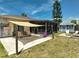 Backyard featuring a paved patio, firepit, well-kept lawn, shed, screened lanai and sunshade at 1789 Elm Dr, Venice, FL 34293