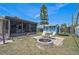 Backyard featuring a paved patio, firepit, well-kept lawn, shed, and a screened lanai at 1789 Elm Dr, Venice, FL 34293