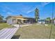 Backyard featuring a paved patio, firepit, well-kept lawn, shed, screened lanai and hammock at 1789 Elm Dr, Venice, FL 34293