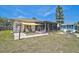 Backyard featuring a paved patio, firepit, well-kept lawn, shed, a screened lanai and sunshade at 1789 Elm Dr, Venice, FL 34293