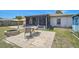 Backyard featuring a paved patio, firepit, well-kept lawn, and a screened lanai at 1789 Elm Dr, Venice, FL 34293
