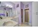 Well-lit bathroom featuring a double sink vanity, shower, and artistic lilac decor at 1789 Elm Dr, Venice, FL 34293