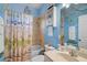 Cheerful blue bathroom with beach-themed decor, a shower-tub combo and vanity at 1789 Elm Dr, Venice, FL 34293