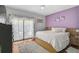 Bright bedroom with hardwood floors, a large bed, and a sliding glass door to the exterior at 1789 Elm Dr, Venice, FL 34293