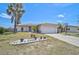 Single-story home featuring an attached two-car garage, manicured lawn, and beautiful landscaping at 1789 Elm Dr, Venice, FL 34293