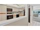 Updated kitchen with white cabinetry and appliances; living room visible in the background at 2100 Benjamin Franklin Dr # 201, Sarasota, FL 34236