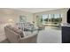 Bright living room featuring comfortable seating, a glass coffee table, and sliding glass doors to the outside at 2100 Benjamin Franklin Dr # 201, Sarasota, FL 34236