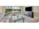 Comfortable living room with neutral décor, including a modern TV stand and sliding glass doors at 2100 Benjamin Franklin Dr # 201, Sarasota, FL 34236