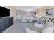 Wide view of the living room with neutral carpet and décor, including a TV console and large couch at 2100 Benjamin Franklin Dr # 201, Sarasota, FL 34236