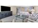 Spacious living room with neutral carpet and decor; featuring a glass table, modern furniture and a TV console at 2100 Benjamin Franklin Dr # 201, Sarasota, FL 34236