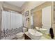 Well-lit bathroom with a modern vessel sink, decorative shower curtain, and neutral tiling at 2221 Bahia Vista St, Sarasota, FL 34239