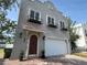 Two-story gray home with a garage, arched wood door, paver driveway and black flower boxes on the second story at 2221 Bahia Vista St, Sarasota, FL 34239