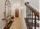 Inviting foyer with arched wood door, elegant mirror and wood staircase at 2221 Bahia Vista St, Sarasota, FL 34239