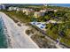 Stunning aerial view showcases beach pavilions, beautiful coastline, and opulent beachfront residences at 2282 Harbour Court Dr, Longboat Key, FL 34228
