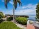 Enjoy the waterfront view from this backyard featuring a lush landscape and sunny skies at 2282 Harbour Court Dr, Longboat Key, FL 34228