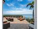 Outdoor patio area featuring lounge chairs and patio furniture and a full ocean view at 2282 Harbour Court Dr, Longboat Key, FL 34228