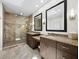 Bright bathroom featuring dual vanities, granite counters, a skylight and glass enclosed shower at 2282 Harbour Court Dr, Longboat Key, FL 34228