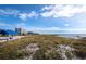 Scenic beach view features sandy dunes, picnic pavilions, and the ocean under a partly cloudy sky at 2282 Harbour Court Dr, Longboat Key, FL 34228