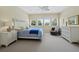 Bright bedroom features carpeted floors, ceiling fan, plantation shutters, and a seating area at 2282 Harbour Court Dr, Longboat Key, FL 34228