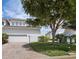 Charming townhome featuring a two-car garage, a brick driveway, and a well-maintained lawn and landscaping at 2282 Harbour Court Dr, Longboat Key, FL 34228