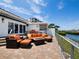 Spacious outdoor patio with waterfront views featuring a fire pit, lounge, and shade at 2282 Harbour Court Dr, Longboat Key, FL 34228