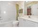 Clean bathroom with tile flooring features a shower-tub combination and neutral palm tree wallpaper at 242 Hidden Bay Dr # 603, Osprey, FL 34229