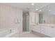Well-lit bathroom with walk-in shower, soaking tub, and double vanity at 242 Hidden Bay Dr # 603, Osprey, FL 34229