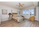 Bedroom with ceiling fan, water view, and light wood floors at 242 Hidden Bay Dr # 603, Osprey, FL 34229