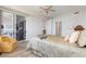 Comfortable bedroom features a ceiling fan, sitting chair, and sliding glass doors to a lanai at 242 Hidden Bay Dr # 603, Osprey, FL 34229