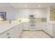 Bright kitchen featuring white cabinetry, updated appliances, and tile flooring with decorative backsplash at 242 Hidden Bay Dr # 603, Osprey, FL 34229