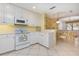 Bright kitchen featuring white cabinetry, matching appliances, and a convenient breakfast bar area at 242 Hidden Bay Dr # 603, Osprey, FL 34229