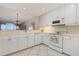 Efficient kitchen with white cabinets, tile floors, and a view of the water at 242 Hidden Bay Dr # 603, Osprey, FL 34229