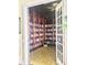 A room filled with wooden bookshelves showcases an extensive library with open french doors at 242 Hidden Bay Dr # 603, Osprey, FL 34229