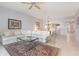 Open living room with a large decorative rug, white sofa, and sight lines to the kitchen at 242 Hidden Bay Dr # 603, Osprey, FL 34229