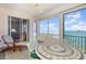 Inviting sunroom features a decorative tile table and comfortable lounge chair with beautiful water views at 242 Hidden Bay Dr # 603, Osprey, FL 34229