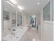 Bright bathroom featuring dual sinks, modern fixtures, and an adjacent laundry area for convenience at 2560 Sunnyside St, Sarasota, FL 34239