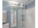 Well-lit bathroom showcasing a glass-enclosed shower, towel rack, and white tiled walls, offering a modern design at 2560 Sunnyside St, Sarasota, FL 34239