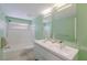 Refreshing bathroom with dual sink vanity, bathtub with shower, and a serene green color scheme at 2560 Sunnyside St, Sarasota, FL 34239